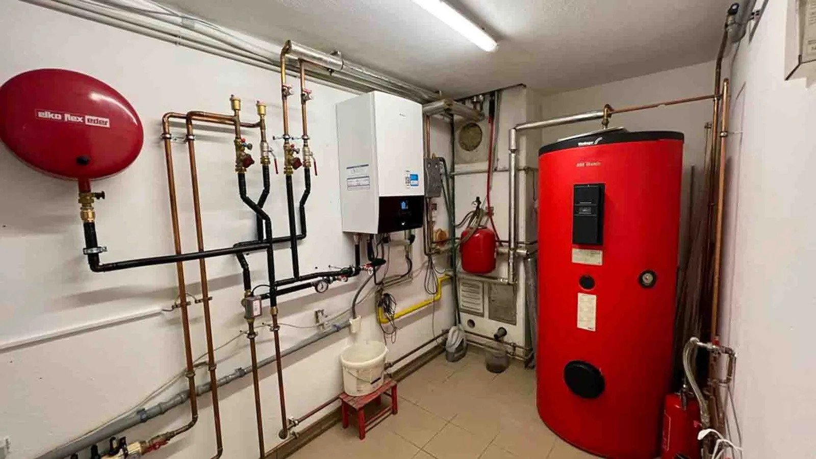 Technikraum mit rotem Speicher, Ausdehnungsgefäß und Kupferrohren