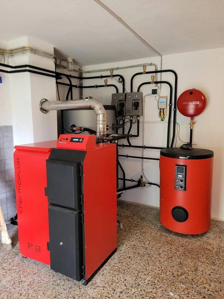 Roter Kessel und roter Speicher in einem Technikraum