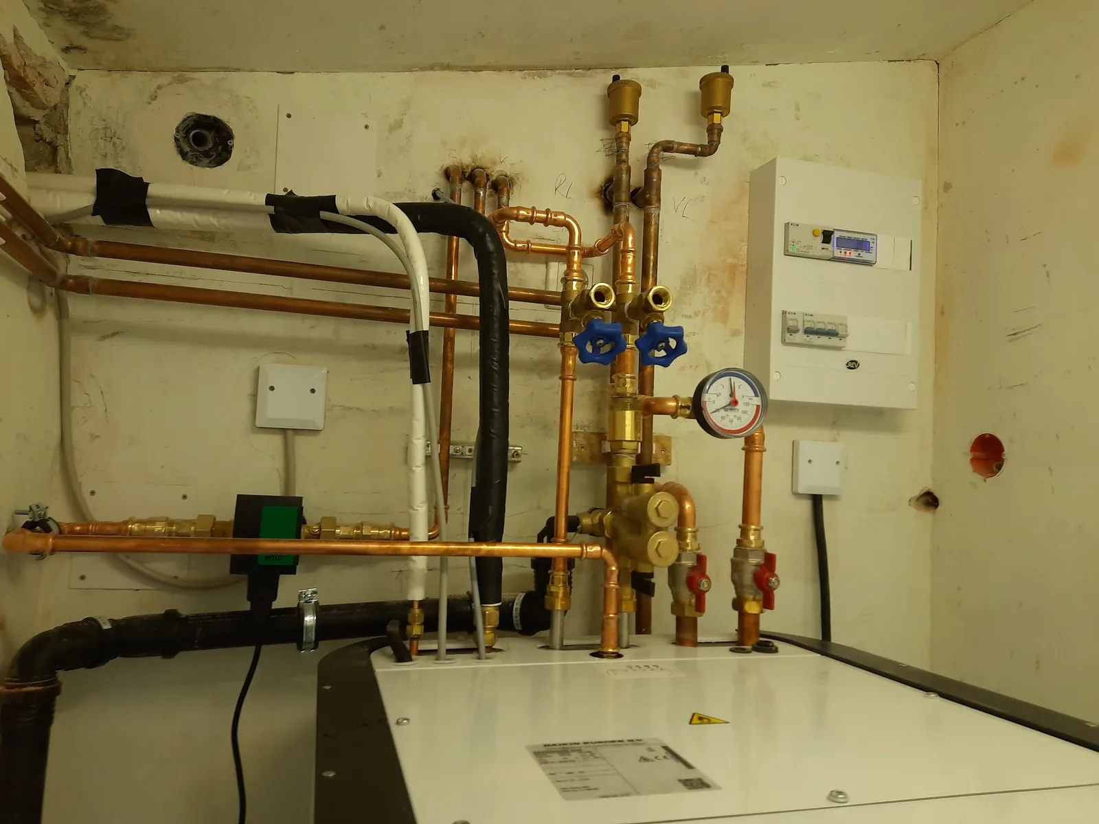 Neue Kupferleitungen, Pumpe und Verteiler in einem Technikraum
