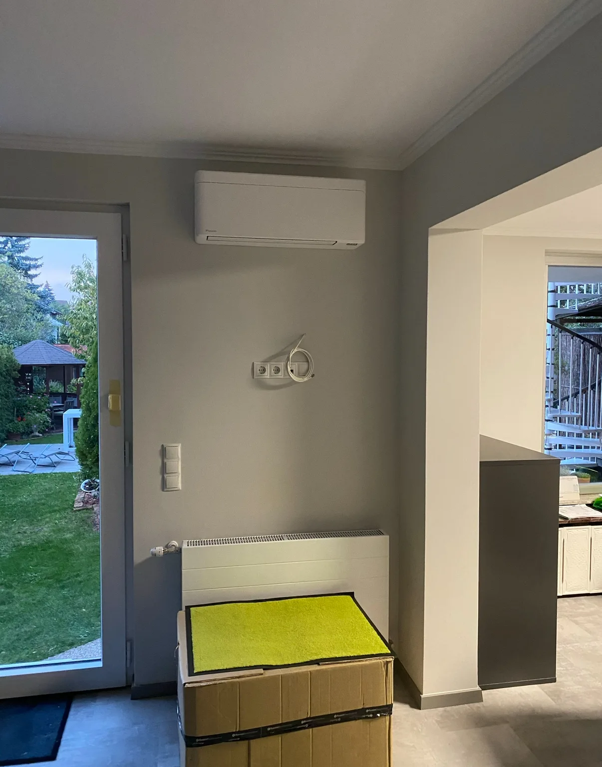 Weißes Wand-Innengerät einer Klimaanlage in einem hellen Wohnraum